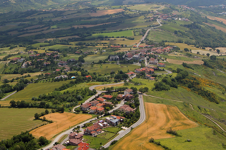 Kiemurteleva tie, peltoja ja asutusta San Marinon maaseudulla