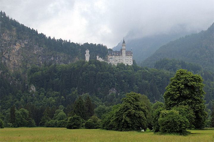 Neuschwansteinin linna metsän keskellä vuoren rinteellä pilvisessä säässä