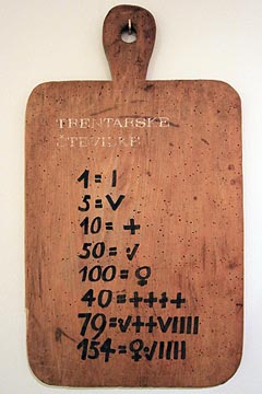 Museoesine: Trentalaiset numerot puulaudalla, roomalaisten numeroiden tapaisia