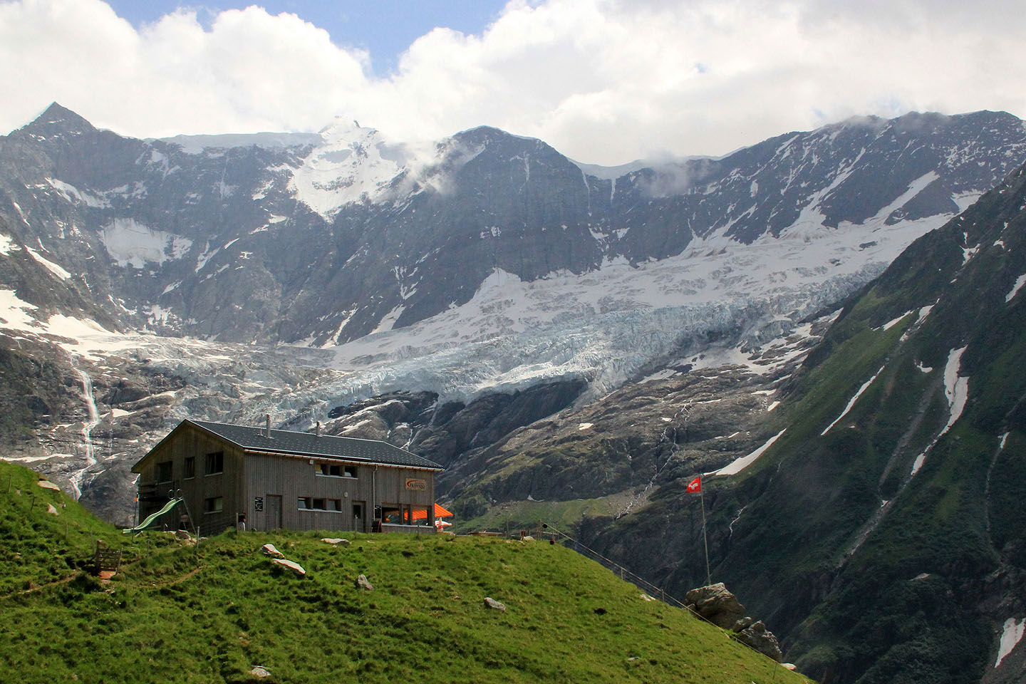 Bäregg: alppimaja vuorenrinteeltä valuvan jäätikön edessä