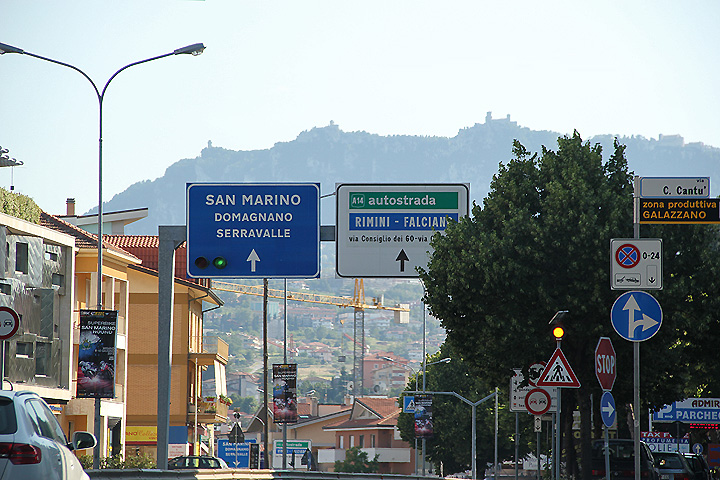 Katunäkymä tienviittoineen, takana San Marinon vanhakaupunki